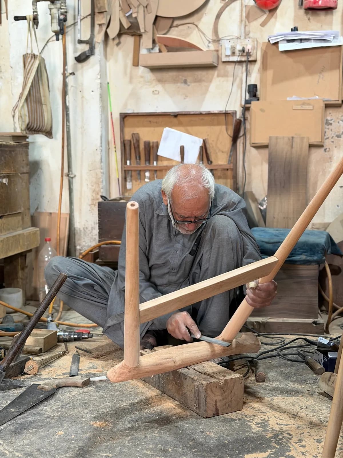 A master craftsman shaping a chair leg at the workbench