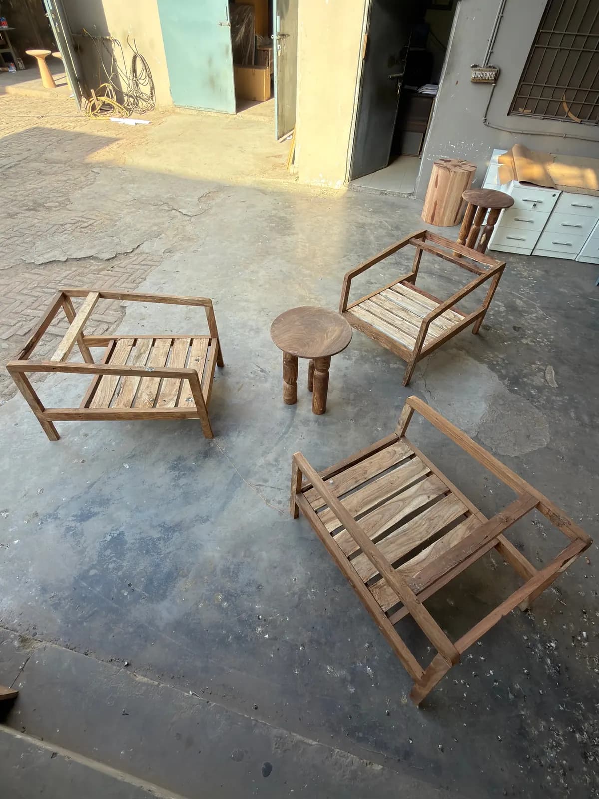 Three lounge chairs and a stool laid out on the workshop floor